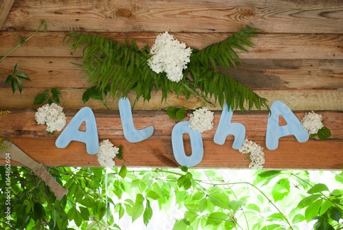 Aloha on wooden background, party Hawaiian-style,