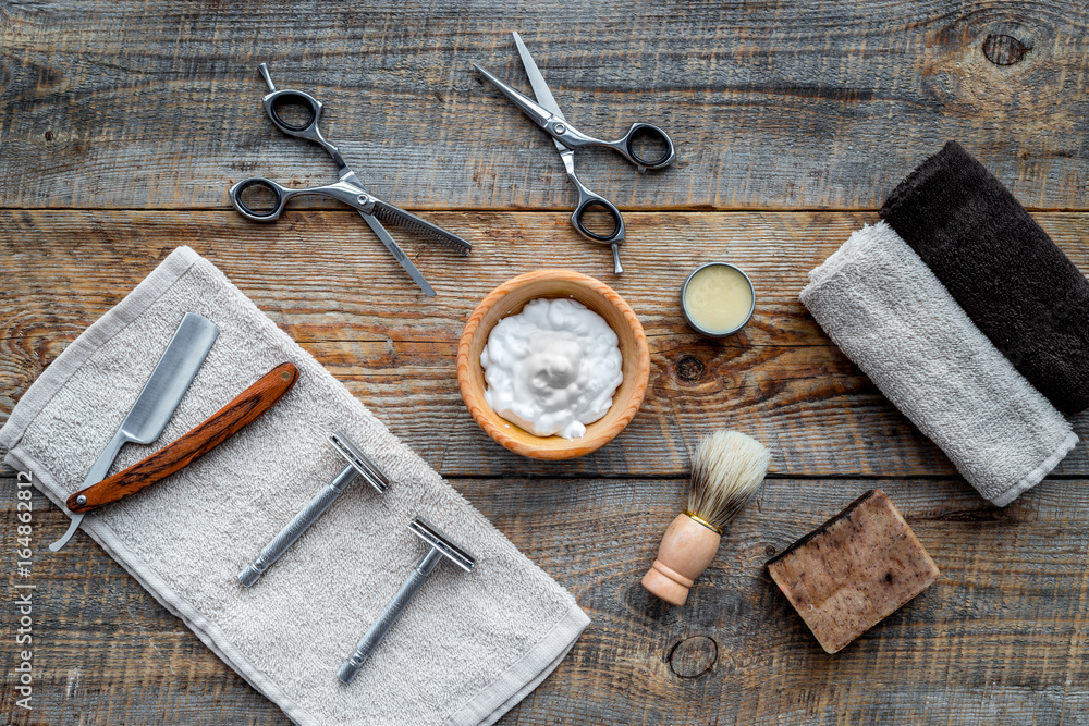 Barbershop. Men's shaving and haircut. Brush, razor, foam, sciccors on wooden table background top view Barbershop. Men's shaving and haircut. Brush, razor, foam, sciccors on wooden table background top view