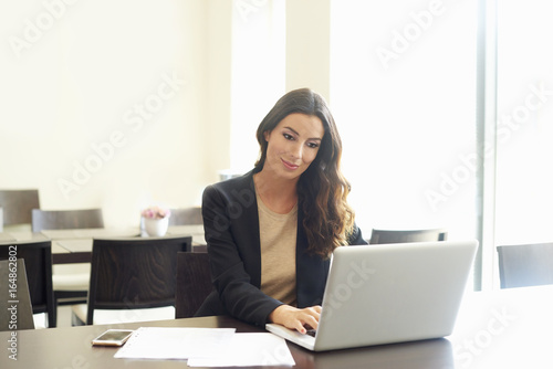 Confident young businesswoman portrait. Shot of a beautiful young professional woman looking thoughtful while sitting at office desk. 