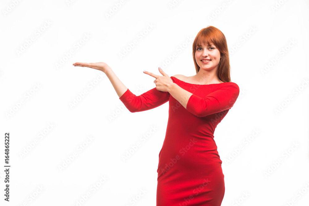 Young happy woman showing by hands on a gray background. Ideal for banners, registration forms, presentation, landings, presenting concept. Young happy woman showing by hands on a gray background. Ideal for banners, registration forms, presentation, landings, presenting concept.