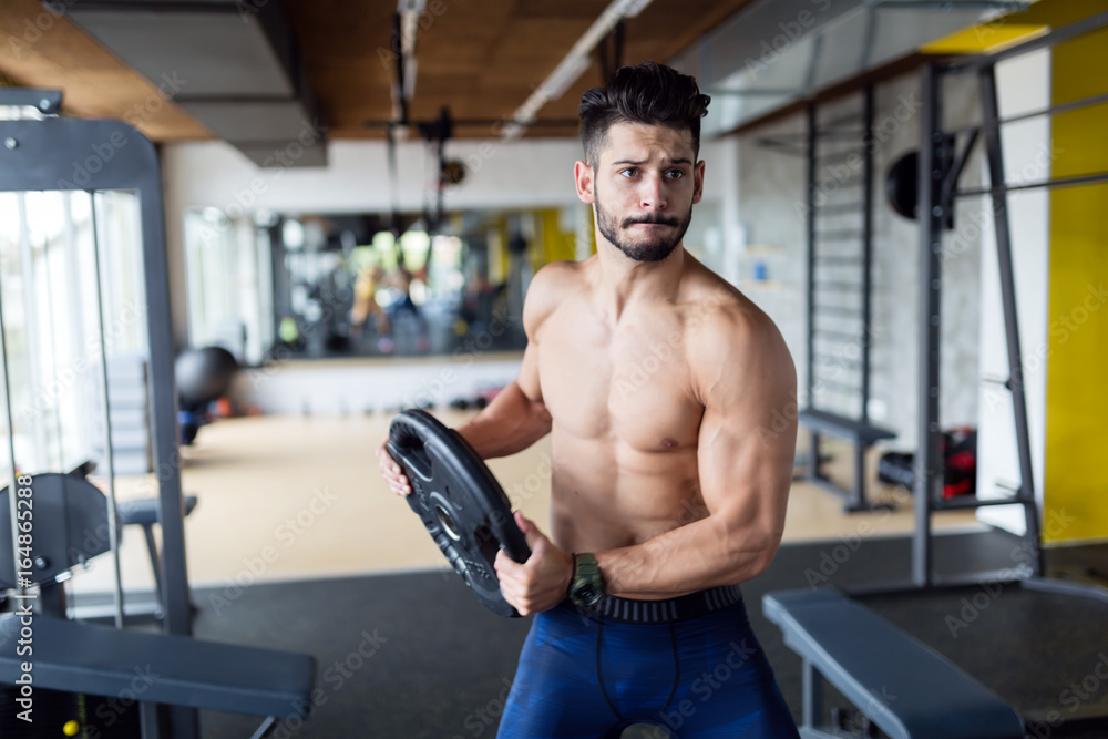 Portrait of young strong man in gym