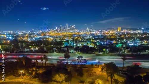 Wallpaper Mural Aerial timelapse in motion (hyperlapse) at night facing downtown Los Angeles with stunning deep blue skies, high rise buildings and car lights with traffic on a busy highway. Torontodigital.ca