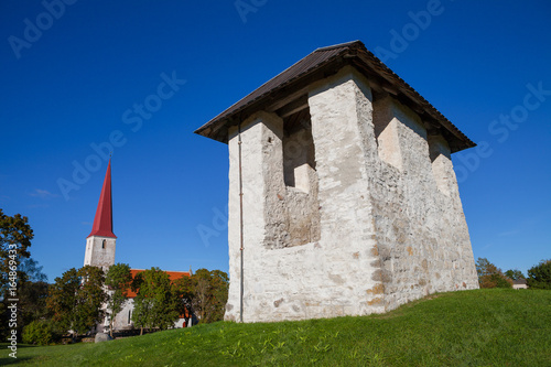 Ancient Lutheran church and bellfry in Kihelkonna, Saaremaa, Estonia. Early autumn sunny day. Landscape view. photo