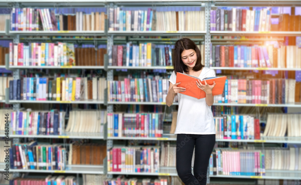 Young Student Asian Women Teenager with school folders reading book at library university campus college knowledge center Young Student Asian Women Teenager with school folders reading book at library university campus college knowledge center