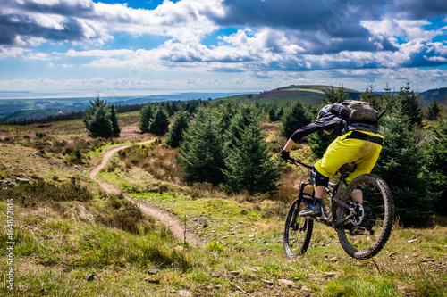 Photos Mountain Biking in Wales - rider speeds down steep flowing trail with river Severn in the background