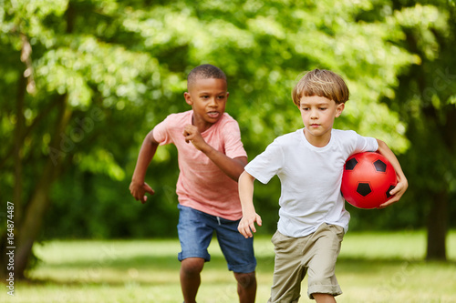 Zwei Jungen beim Wettlauf mit Fußball