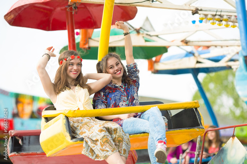 Cheerful and excited teenage girls are enjoying their funfair ride