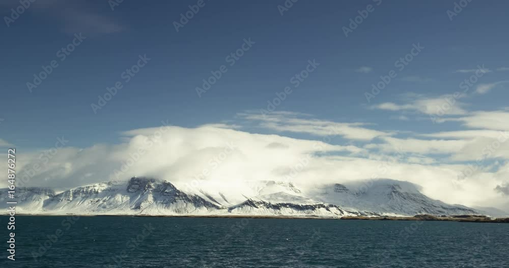 Clouds over snow-capped mountaintops, wide Clouds over snow-capped mountaintops, wide
