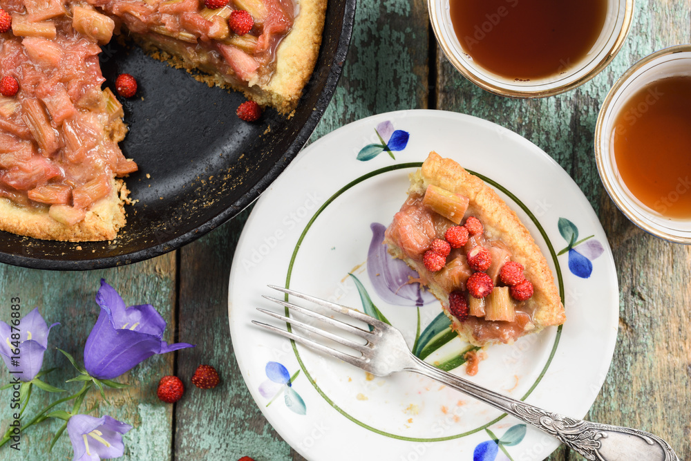 Rustic rhubarb pie with fresh forest strawberries baked in cast iron skillet served with black tea and vintage forks Rustic rhubarb pie with fresh forest strawberries baked in cast iron skillet served with black tea and vintage forks