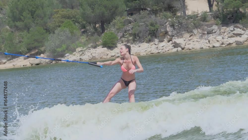 blond girl surfing to one hand on a wakesurf boat blond girl surfing to one hand on a wakesurf boat