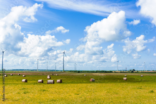 landscape with wind power millls and hay rolls photo