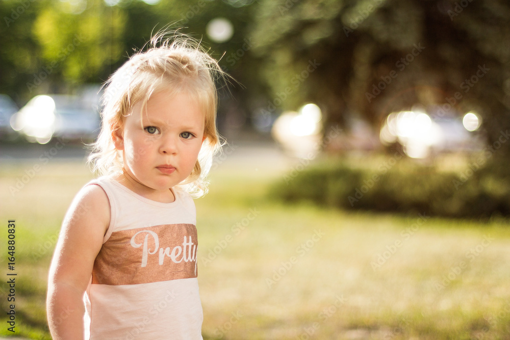 Upset little girl in the park, space for text.