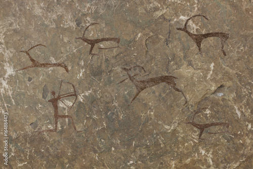 Figure animals and hunter on the stone wall of the cave paint ocher ancient prehistoric Neanderthal. prehistoric animal, stone age hunting for deer. primitive man