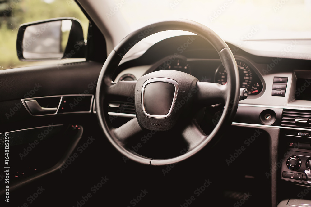 black leather steering wheel closeup.