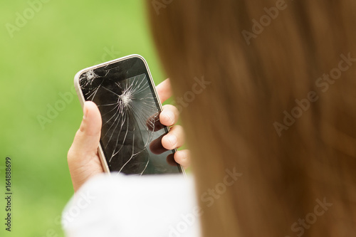 Εκτύπωση καμβά little girl in desperation is holding a phone with a broken screen