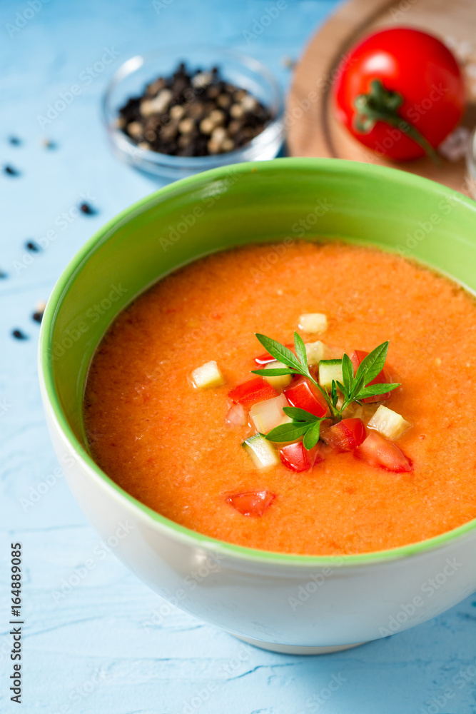 Summer cold soup gazpacho with parsley and vegetables on blue concrete background. Summer cold soup gazpacho with parsley and vegetables on blue concrete background.