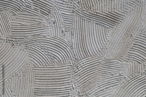 grey decorative relief plaster on wall closeup, background texture