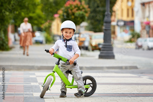 Happy boy in white helmet ride his first bike © Aleksey