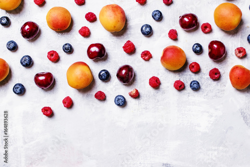 Food background, apricots, blueberries, raspberry and sweet cherry, top view