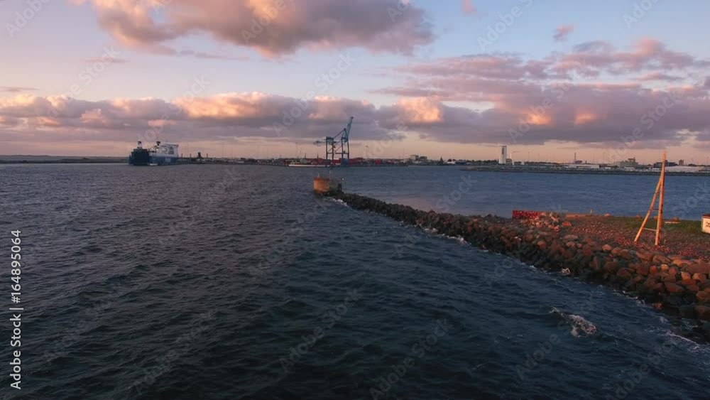 Aerial shot of sea coast and cargo container terminal harbor at dusk. Ship at the dock Aerial shot of sea coast and cargo container terminal harbor at dusk. Ship at the dock