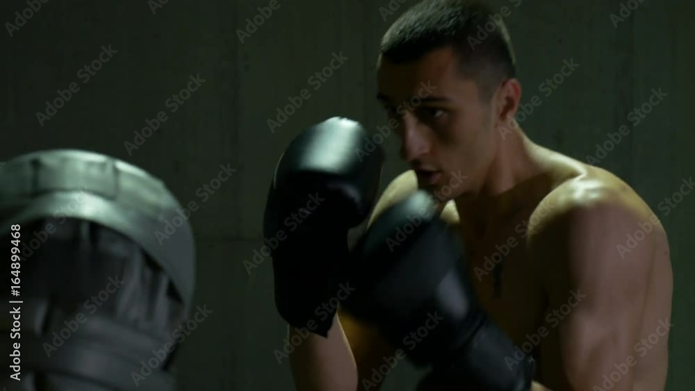 Male boxer punching gloves of his trainer Male boxer punching gloves of his trainer