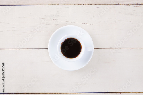 Top view of empty white cup coffee with black coffee put on white wood table with space for copy.