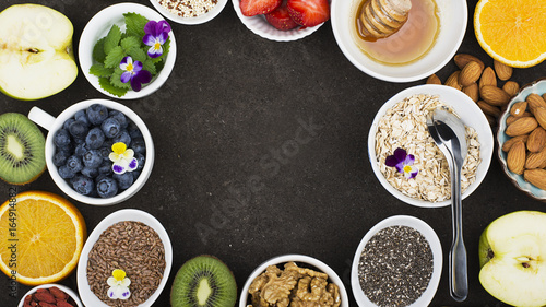 Ingredients for a healthy breakfast, nuts, oatmeal, honey, berries, fruits, blueberry, orange, Strawberry, Edible flowers, Chia seeds, flax seeds, goji berries, almonds, walnuts The concept of natural