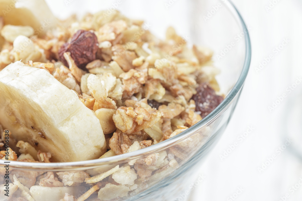 Homemade granola with banana, nuts and raisins closeup. Selective focus