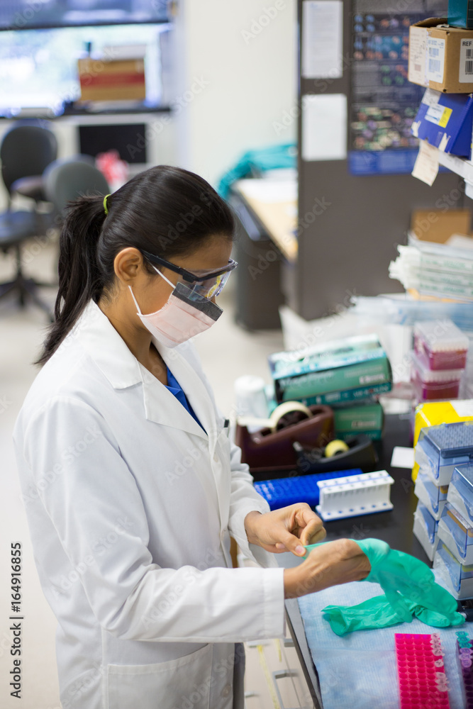 Closeup portrait, young scientist in labcoat doing experiments in lab background, academic sector. Closeup portrait, young scientist in labcoat doing experiments in lab background, academic sector.