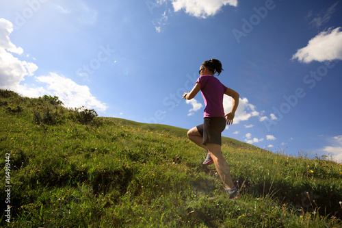 healthy lifestyle woman trail runner running on mountain trail