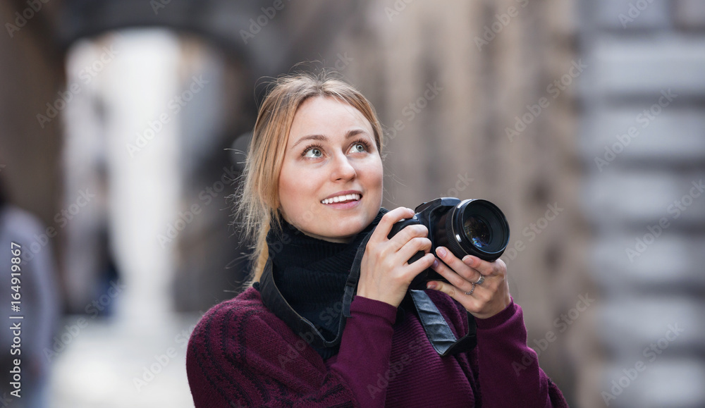 Girl taking picture with camera in the town