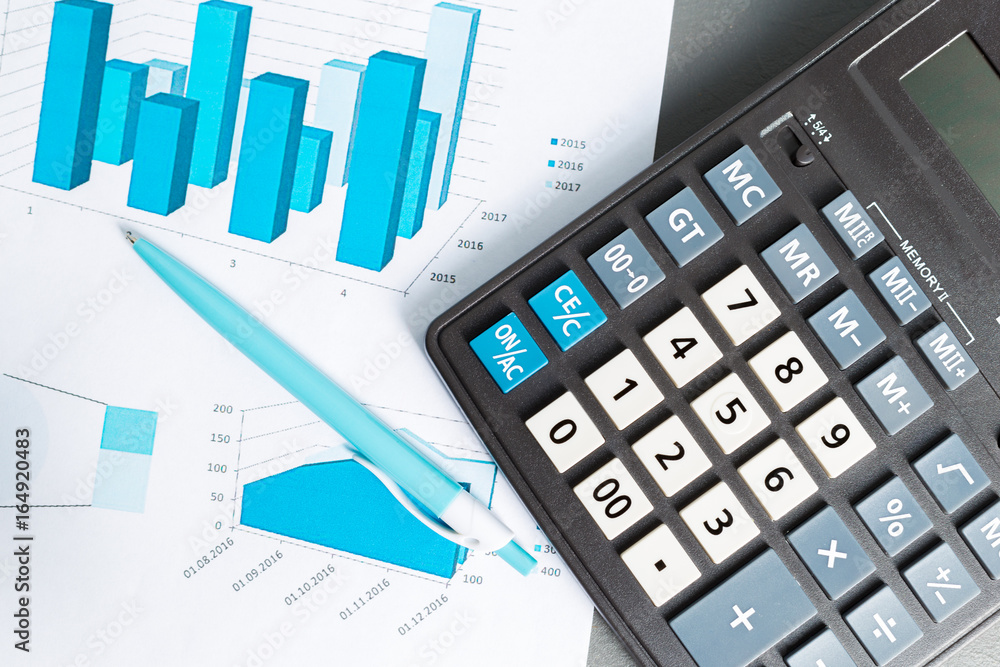 Checking accounting report on business table. Calculator Checking accounting report on business table. Calculator