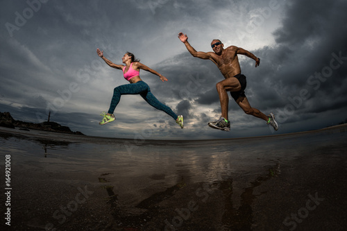Sport couple runnig on the beach