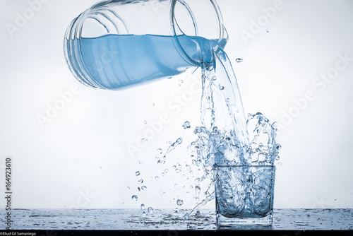 jarra de agua llenando vaso con splash