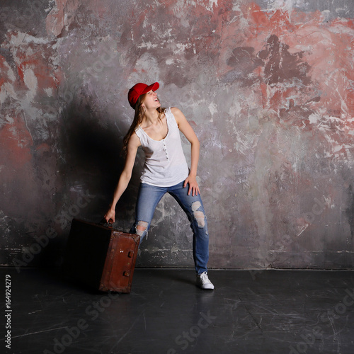 Woman holding suitcase, on gray background, indoor, travel a journey, hard