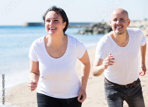 Mature couple jogging together .