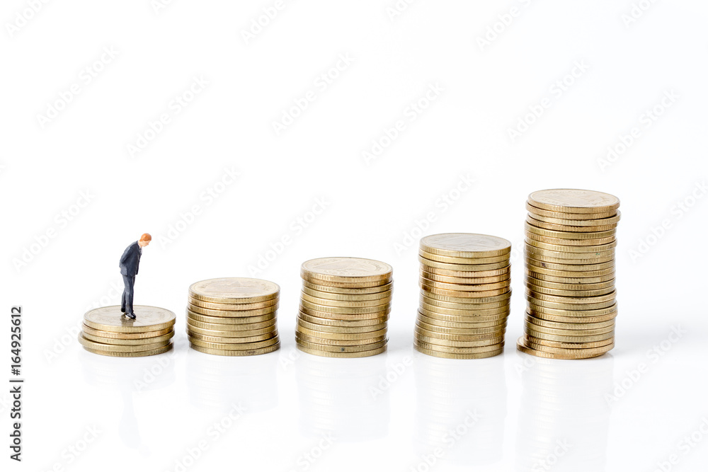 Miniature model of businessman walking on coin with project for investment . Miniature model of businessman walking on coin with project for investment .