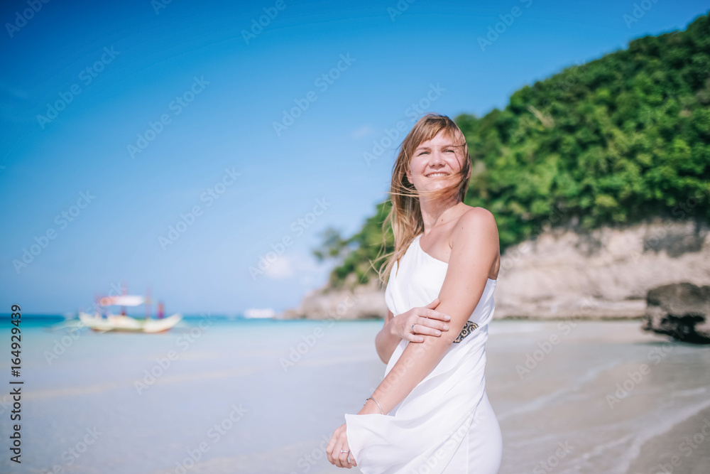 Portrait of the beautiful blond long hair woman dancing on the beach. Happy island lifestyle. White sand, blue cloudy sky and crystal sea of tropical beach. Vacation on the paradise island. Portrait of the beautiful blond long hair woman dancing on the beach. Happy island lifestyle. White sand, blue cloudy sky and crystal sea of tropical beach. Vacation on the paradise island.