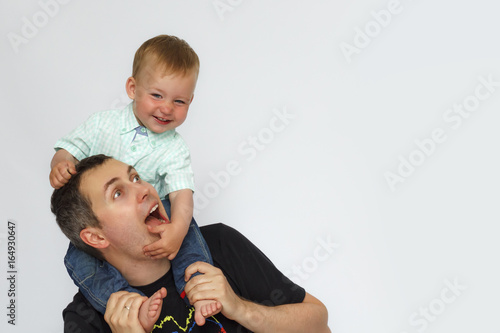 Baby sitting on father neck on white background photo