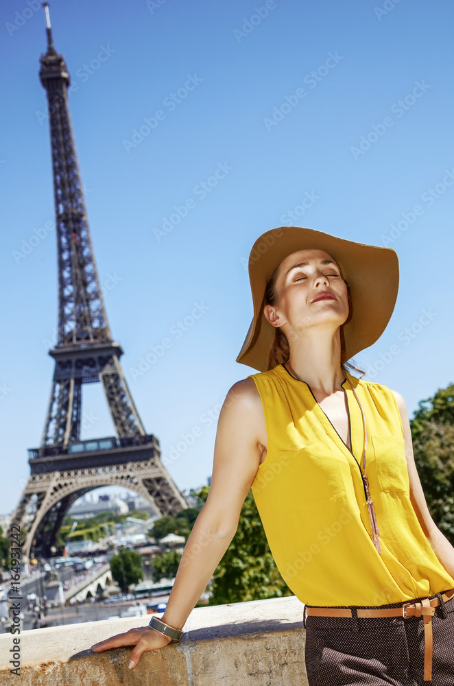 relaxed woman in bright blouse against Eiffel tower in Paris