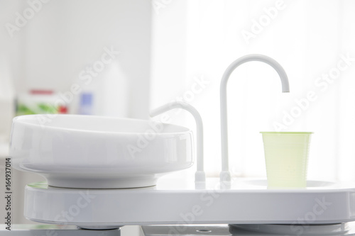 Spültisch / Spülarmatur mit grünen Becher in der Zahnarzt Praxis