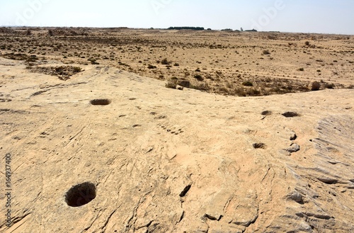 Rocky deserted landscape with ancient petroglyphs at Jebel Jassassiyeh site in Northern Qatar.
