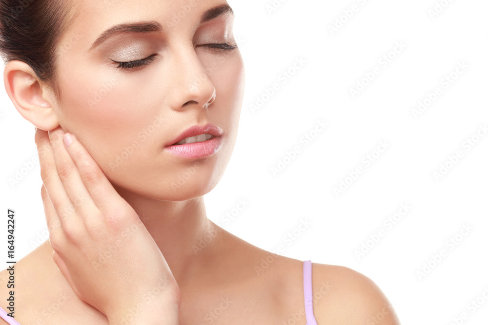 Closeup view of beautiful young woman with natural lips makeup touching neck on white background