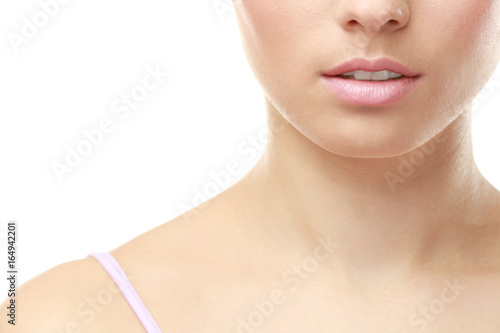 Closeup view of beautiful young woman with natural lips makeup on white background