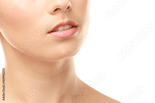 Closeup view of beautiful young woman with natural lips makeup on white background