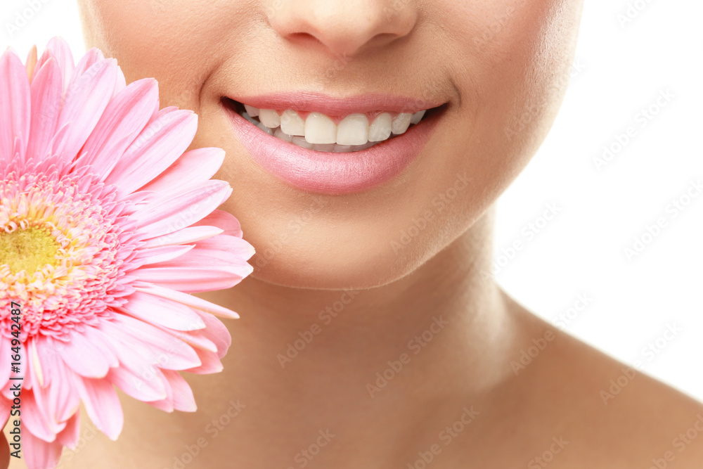 Closeup view of beautiful young woman with natural lips makeup and flower on white background Closeup view of beautiful young woman with natural lips makeup and flower on white background