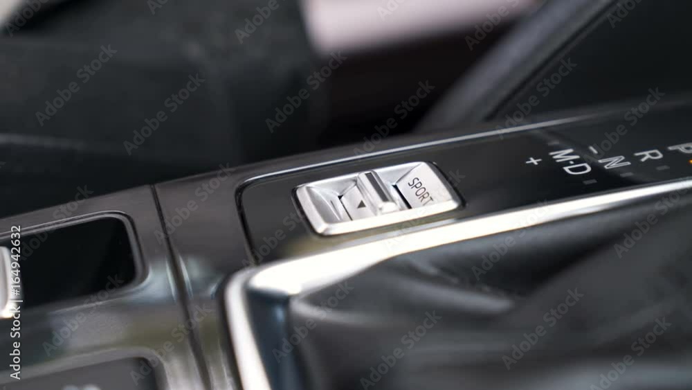 Finger pressing the sport mode button of a modern car. 4K video with shallow depth of field focus on the hand Finger pressing the sport mode button of a modern car. 4K video with shallow depth of field focus on the hand