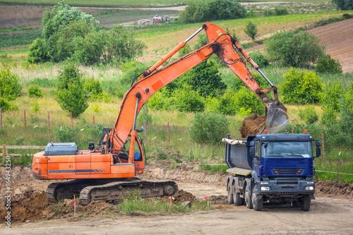 An excavator loading ground into the truck