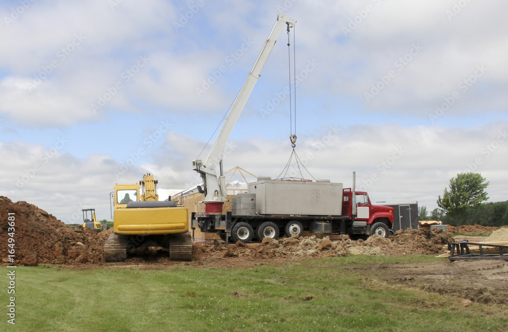 Crane lifting septic tanks