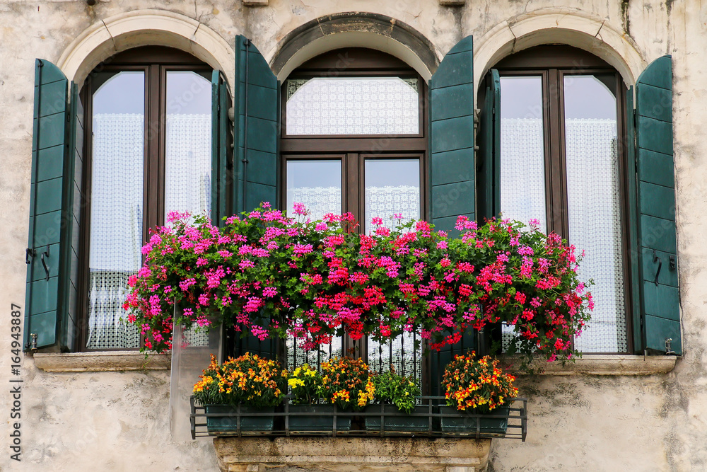 Detail of a building with window and flower box in Venice, Italy